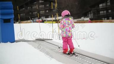 冬季户外运动中的小女孩呆在滑雪传送带上。 孩子开始滑雪了。 度假村快乐滑雪<strong>体验</strong>。